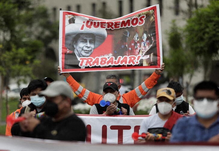 &copy; Reuters. Foto de archivo. Trabajadores de la mina Las Bambas sostienen un cartel con una foto del presidente de Perú, Pedro Castillo y el titular que dice "Queremos trabajar", durante una protesta contra la suspensión de la mina, en Lima, Perú, el 13 de diciemb