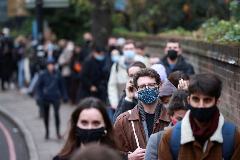 &copy; Reuters. FILE PHOTO: People queue for their booster dose outside a coronavirus disease (COVID-19) vaccination centre in London, Britain, December 14, 2021. REUTERS/Hannah McKay