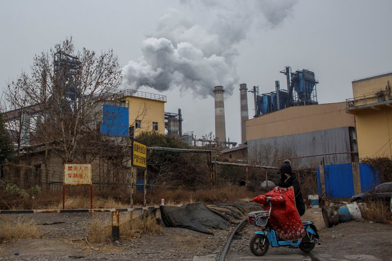 &copy; Reuters. FOTO DE ARCHIVO: Una mujer frente a una planta de acero en Anyang, provincia de Henan, China, 18 de febrero de 2019. Foto tomada el 18 de febrero de 2019.  REUTERS/Thomas Peter