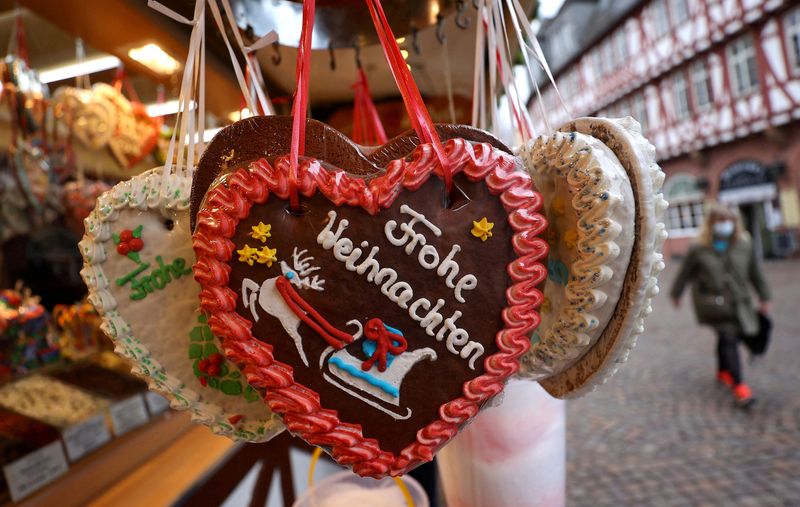 &copy; Reuters. FILE PHOTO: A woman wearing a mandatory protective face mask passes by a heart-shaped ginger bread reading "Merry Christmas" at the Christmas market, as the spread of the coronavirus disease (COVID-19) pandemic continues, in Frankfurt, Germany, November 2