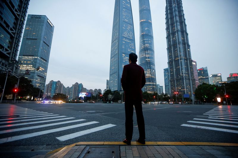 &copy; Reuters. FILE PHOTO: A man stands at a crossroads in Lujiazui financial district in Pudong, Shanghai, on the day of the opening session of the National People's Congress (NPC), China March 5, 2021. REUTERS/Aly Song