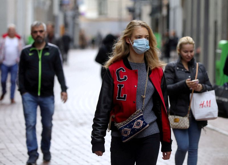 &copy; Reuters. FILE PHOTO: People with and without protective masks walk on the street while shopping as the spread of coronavirus disease (COVID-19) continues in Amsterdam, Netherlands October 7, 2020. REUTERS/Eva Plevier/File Photo