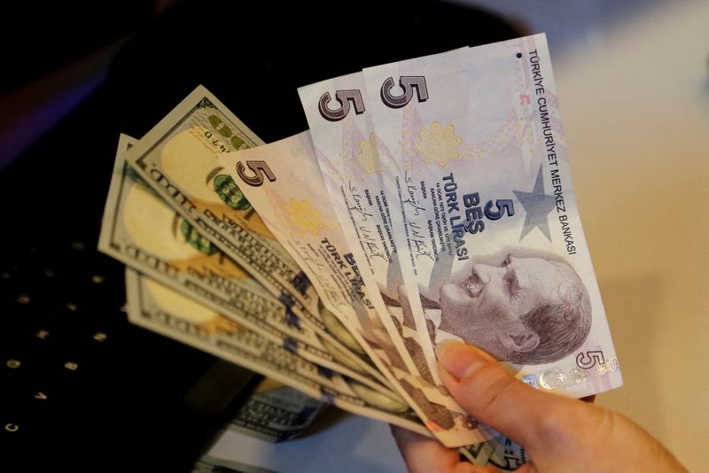 &copy; Reuters. A money changer holds Turkish lira  and U.S. dollar banknotes at a currency exchange office in Ankara, Turkey December 16, 2021. REUTERS/Cagla Gurdogan