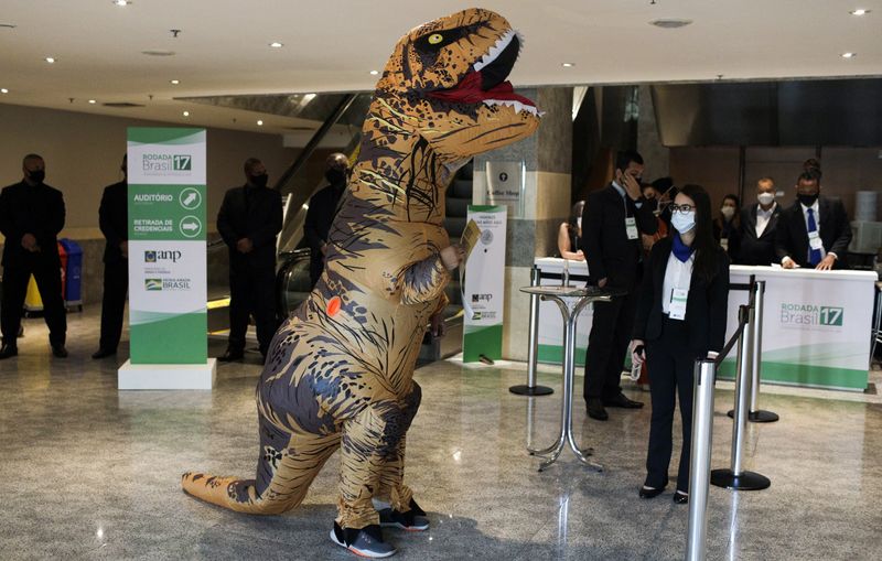 &copy; Reuters. FILE PHOTO: A demonstrator wearing a dinosaur costume protests against an auction of exploratory offshore oil blocks in the Campos, Santos, Pelotas and Potiguar basins, which draws interest from oil majors including Chevron, Shell, Total and Petrobras, in