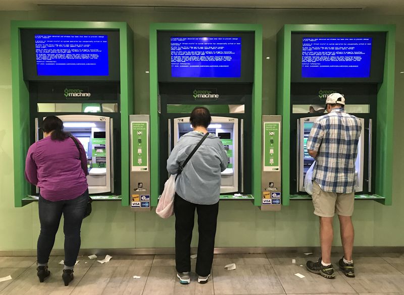 &copy; Reuters. FILE PHOTO: Customers use Toronto Dominion (TD) Bank ATM cash machines under video information screens showing a computer error in Toronto, Ontario, Canada June 24, 2017.  REUTERS/Chris Helgren/File Photo