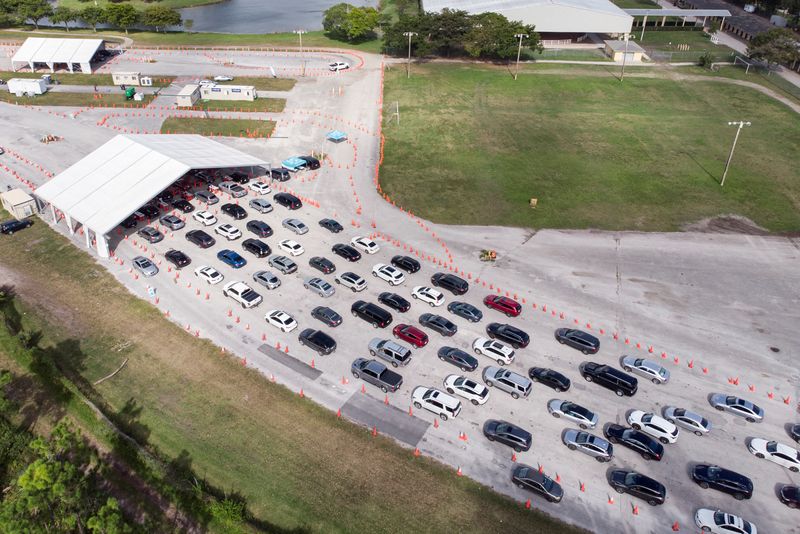 © Reuters. Cars wait in line at a COVID-19 drive-through testing site at Tropical Park, in Miami, Florida, U.S. December 17, 2021. REUTERS/Marco Bello