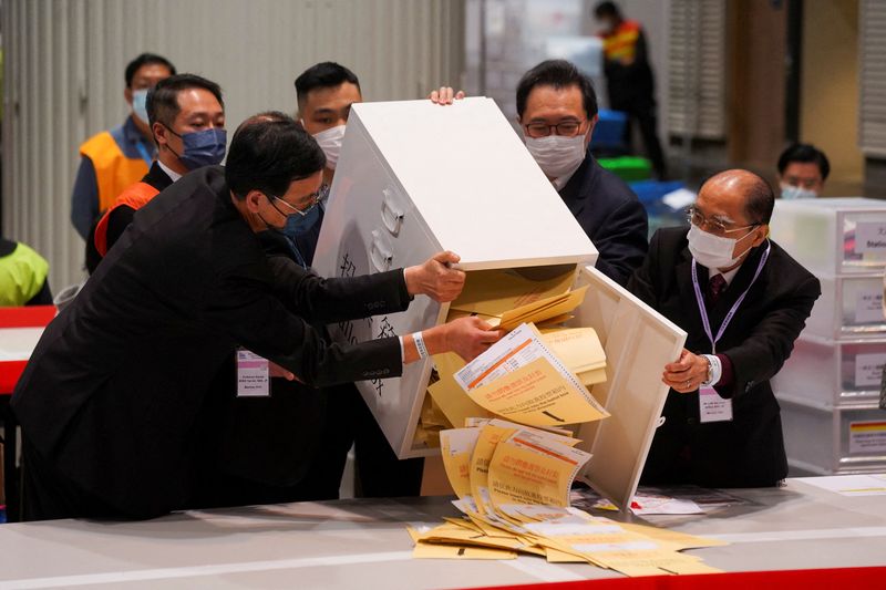 © Reuters. The chairman of Electoral Affairs Commission Barnabas Fung Wah and other members of EAC open the ballot box for the Legislative Council election at a vote counting centre, in Hong Kong, China December 19, 2021. REUTERS/Lam Yik