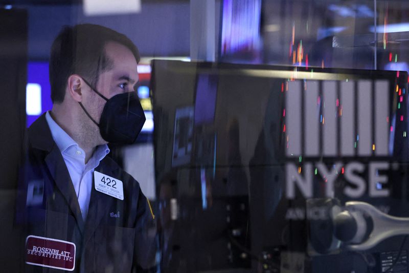 © Reuters. A trader in a face mask works on the trading floor at the New York Stock Exchange (NYSE) in Manhattan, New York City, U.S., December 17, 2021. REUTERS/Andrew Kelly