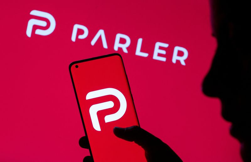 &copy; Reuters. FILE PHOTO: Woman holding smartphone with Parler logo in front of displayed same logo in this illustration taken May 17, 2021. REUTERS/Dado Ruvic