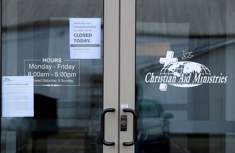 © Reuters. FILE PHOTO: Signs on the door of the Christian Aid Ministries give updates on the Haiti kidnapping and show the the offices are closed in Millersburg, Ohio, U.S. October 21, 2021.  REUTERS/Aaron Josefczyk/File Photo