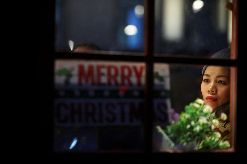 &copy; Reuters. A woman visits a Christmas market in London, Britain, December 20, 2021. REUTERS/Hannah McKay