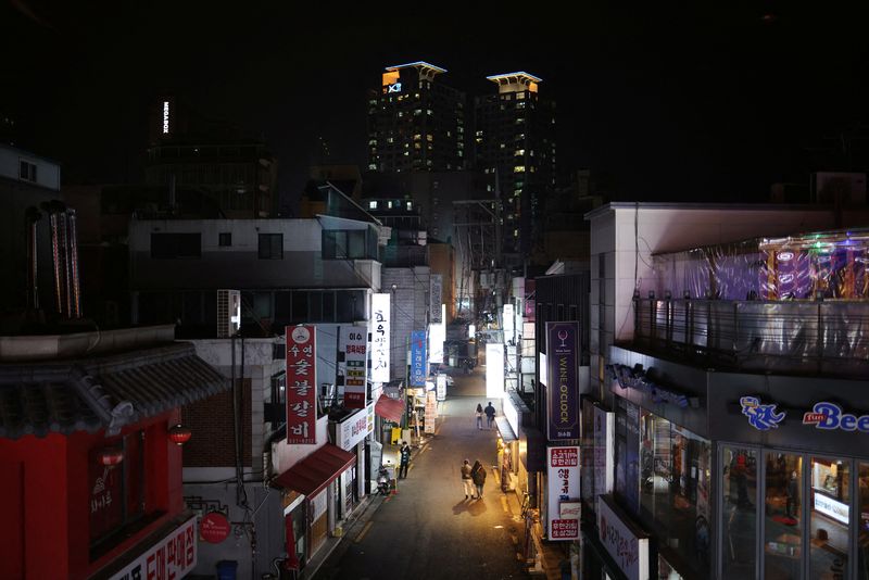 &copy; Reuters. Couples leave a pub during the curfew hours starting at 9:00 p.m., as part of tightened social distancing rules to contain a surge in coronavirus disease (COVID-19) infections, in Seoul, South Korea, December 20, 2021.  REUTERS/Kim Hong-Ji