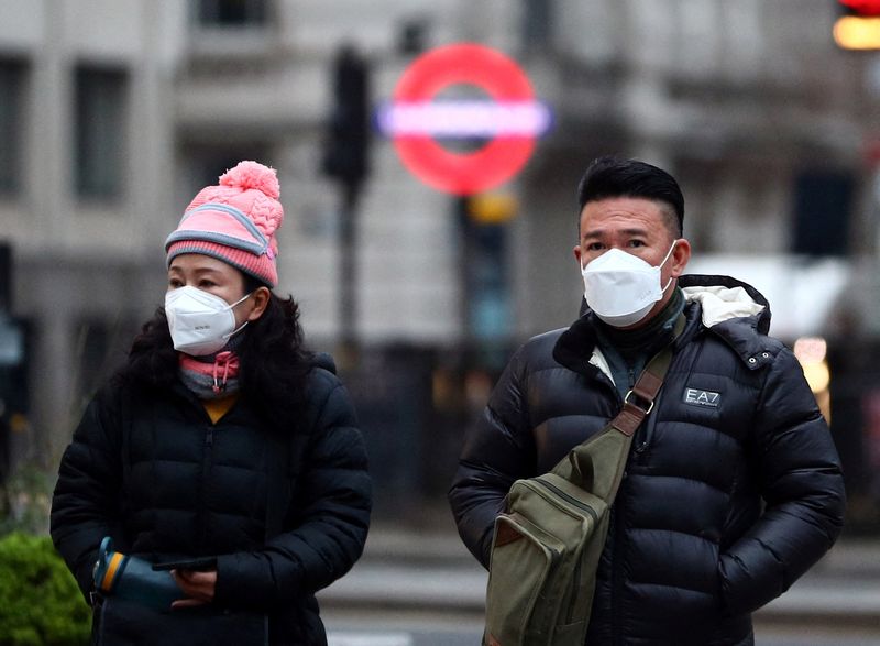 © Reuters. People wearing masks walk through the City of London, as the spread of the coronavirus disease (COVID-19) continues in London, Britain, December 21, 2021. REUTERS/Hannah McKay