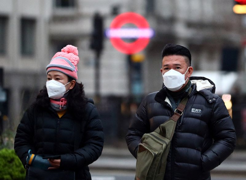 &copy; Reuters. People wearing masks walk through the City of London, as the spread of the coronavirus disease (COVID-19) continues in London, Britain, December 21, 2021. REUTERS/Hannah McKay