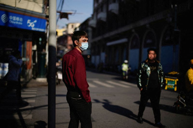 &copy; Reuters. FOTO DE ARCHIVO: Un hombre con mascarilla en una calle de Shanghái, China, el 20 de diciembre de 2021. REUTERS/Aly Song
