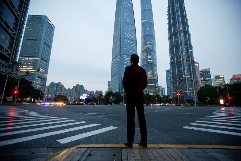 &copy; Reuters. FILE PHOTO: A man stands at a crossroads in Lujiazui financial district in Pudong, Shanghai, on the day of the opening session of the National People's Congress (NPC), China March 5, 2021. REUTERS/Aly Song/File Photo