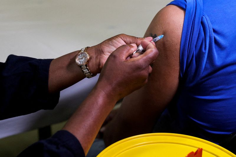 &copy; Reuters. FILE PHOTO: A healthcare worker administers the Pfizer coronavirus disease (COVID-19) vaccine to a man, amidst the spread of the SARS-CoV-2 variant Omicron, in Johannesburg, South Africa, December 9, 2021. REUTERS/Sumaya Hisham