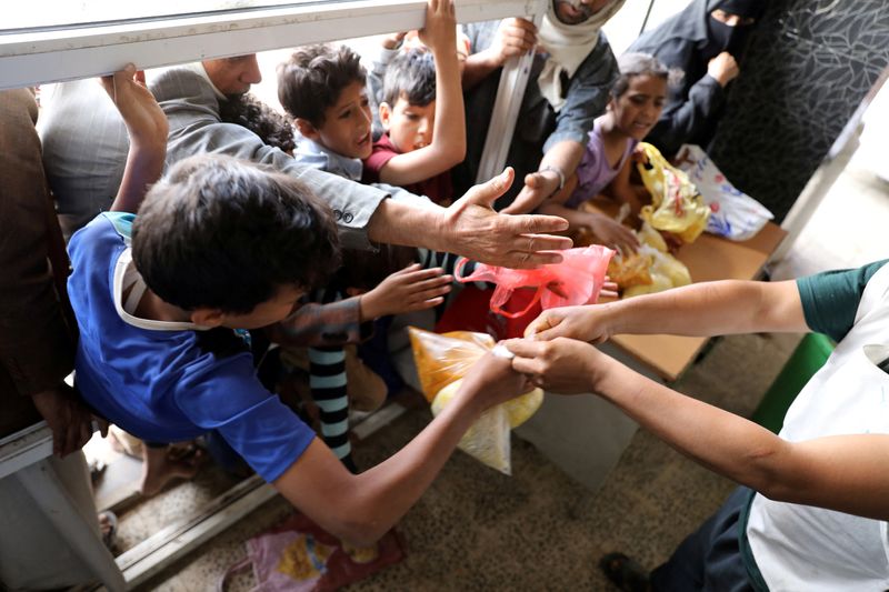 &copy; Reuters. FOTO DE ARCHIVO: Varias personas esperan a recibir raciones de alimentos en una cocina social en Saná, Yemen, el 20 de julio de 2020. REUTERS/Khaled Abdullah