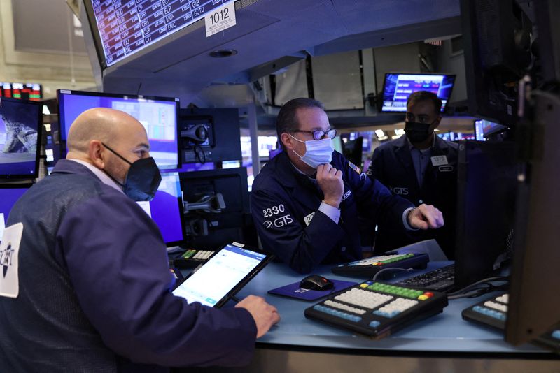 &copy; Reuters. FILE PHOTO: Traders wearing face masks work on the trading floor at the New York Stock Exchange (NYSE) as the Omicron coronavirus variant continues to spread in Manhattan, New York City, U.S., December 20, 2021. REUTERS/Andrew Kelly