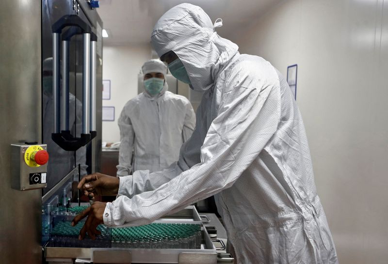 &copy; Reuters. FILE PHOTO: An employee in personal protective equipment (PPE) removes vials of AstraZeneca's COVISHIELD, coronavirus disease (COVID-19) vaccine from a visual inspection machine inside a lab at Serum Institute of India, Pune, India, November 30, 2020. REU