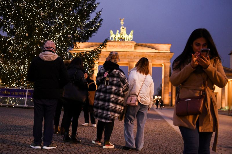 © Reuters. Pessoas passam perto de árvore de Natal no Portão de Brandemburgo, em Berlim
21/12/2021 REUTERS/Annegret Hilse