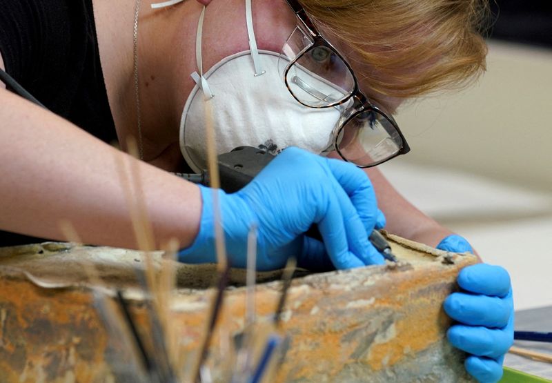 &copy; Reuters. Chelsea Blake, a conservator with the Virginia Department of Historic Resources, attempts to open what is believed to be a time capsule found in Confederate General Robert E. Lee's monument, which was buried in 1887, in Richmond, Virginia, U.S., December 
