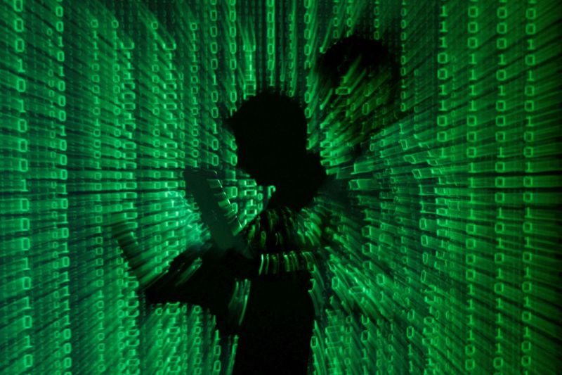 &copy; Reuters. FILE PHOTO: An illustration picture shows a projection of binary code on a man holding a laptop computer, in an office in Warsaw June 24, 2013. REUTERS/Kacper Pempel/File Photo
