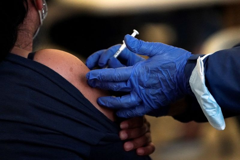 &copy; Reuters. A Los Angeles County Department of Public Health worker administers a dose of a coronavirus disease (COVID-19) vaccine at a pop-up clinic at Tom Bradley International Terminal at Los Angeles International Airport, California, U.S. December 22, 2021. REUTE