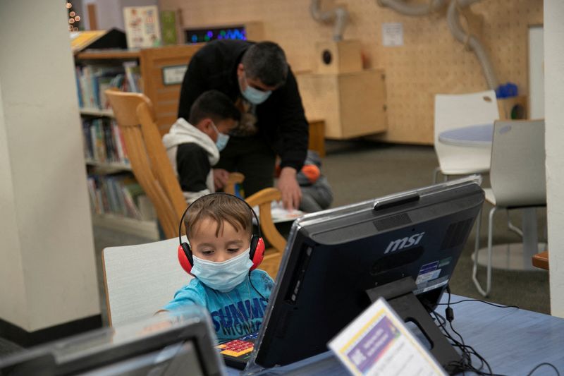 &copy; Reuters. FILE PHOTO: Mirwais Khan Zadran, 2, uses the computer at the library in Bowling Green, Kentucky, U.S., November 27 2021. The Zadran family, Afghan refugees fleeing the Taliban, came to Bowling Green after a spell at a New Mexico military base. They secure