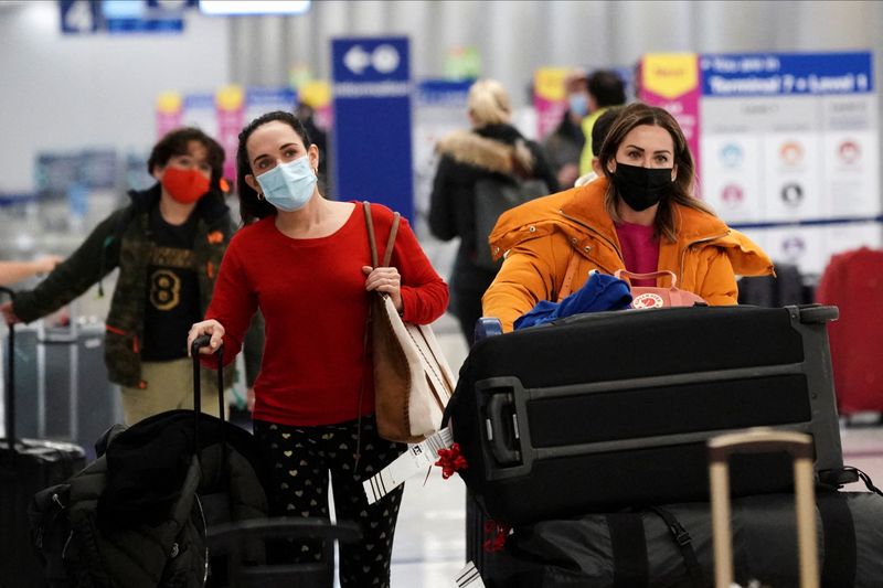 &copy; Reuters. FILE PHOTO: Travelers push their luggage past baggage claim inside the United Airlines terminal at Los Angeles International Airport (LAX) during the holiday season as the coronavirus disease (COVID-19) Omicron variant threatens to increase case numbers i