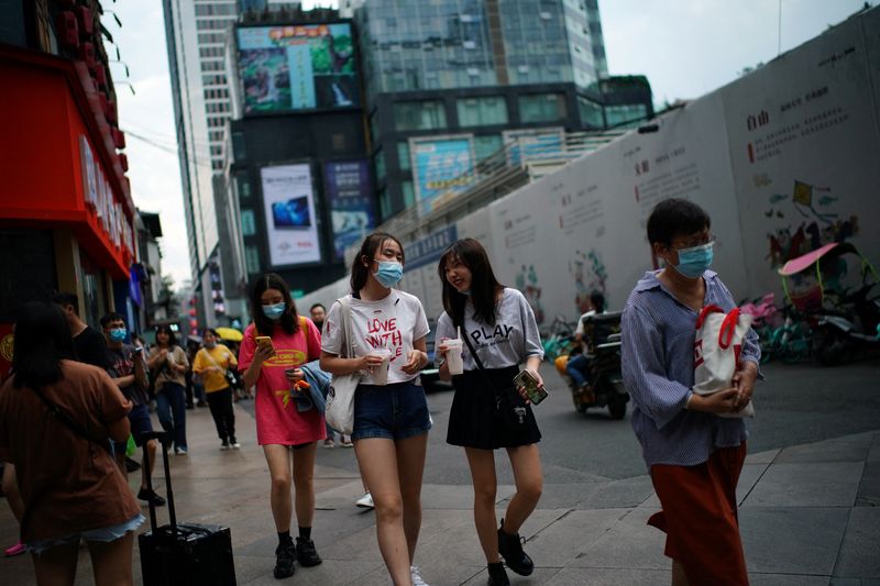 &copy; Reuters. FILE PHOTO: People wearing face masks walk at a shopping area following the coronavirus disease (COVID-19) outbreak, in Chengdu, Sichuan province, China September 8, 2020. REUTERS/Tingshu Wang