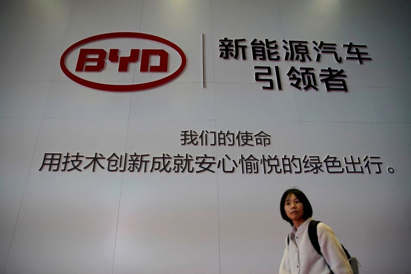 © Reuters. FILE PHOTO: A woman walks past a BYD sign at the second media day for the Shanghai auto show in Shanghai, China April 17, 2019.  REUTERS/Aly Song