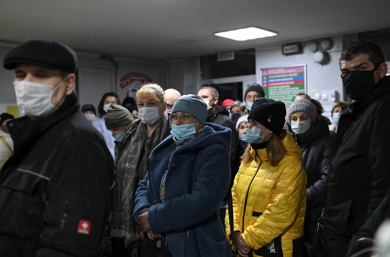 &copy; Reuters. People wearing protective face masks, used as a preventive measure against the spread of the coronavirus disease (COVID-19), stand in a queue at a local clinic in Omsk, Russia November 9, 2020. REUTERS/Alexey Malgavko