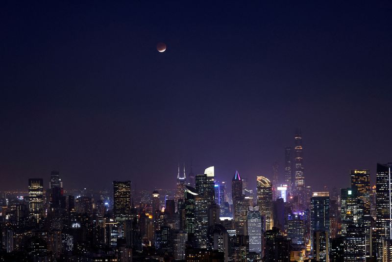 © Reuters. FILE PHOTO: Lunar eclipse rises over the skyline of Shanghai, China November 19, 2021. REUTERS/Aly Song/File Photo