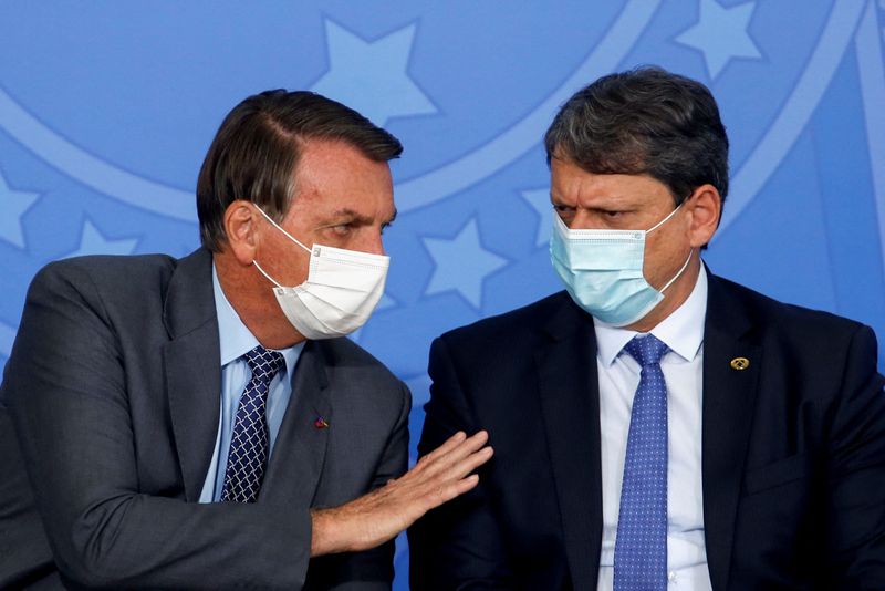 &copy; Reuters. Brazil's President Jair Bolsonaro talks with Brazil's Infrastructure Minister Tarcisio Freitas during the launching ceremony of the program "Gigantes do Asfalto" to encourage actions in the road freight transport sector, at the Planalto Palace, in Brasili