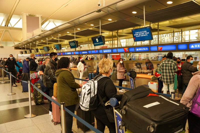 © Reuters. Passengers line up at John F. Kennedy International Airport after airlines announced numerous flights were canceled during the spread of the Omicron coronavirus variant on Christmas Eve in Queens, New York City, U.S., December 24, 2021. REUTERS/Dieu-Nalio Chery