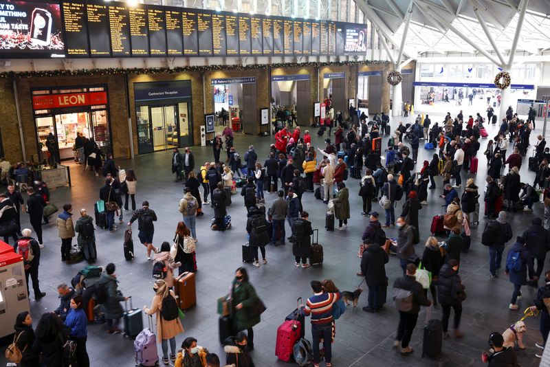 © Reuters. People stand inside Kings Cross Station on Christmas Eve, amid the coronavirus disease (COVID-19) outbreak in London, Britain, December 24, 2021. REUTERS/Henry Nicholls