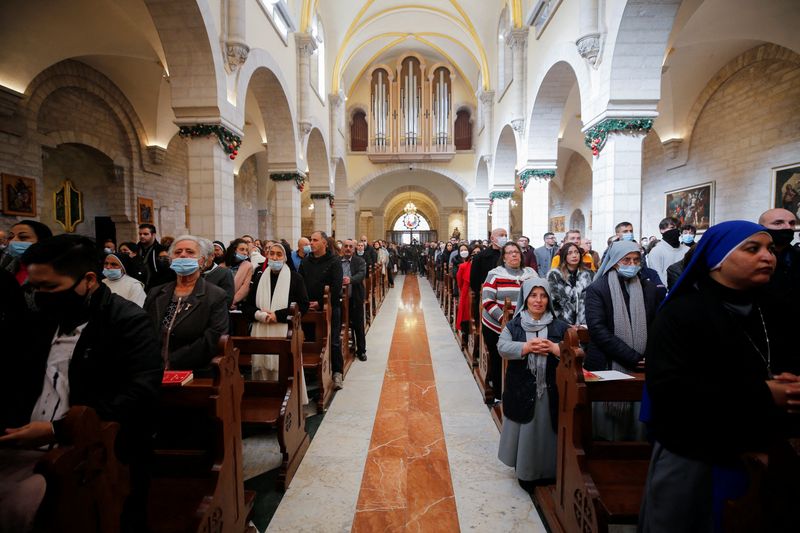 &copy; Reuters. Worshipers attend Christmas morning mass at Saint Catherine's Church, in the Church of the Nativity, in Bethlehem in the Israeli-occupied West Bank, December 25, 2021. REUTERS/Mussa Qawasma