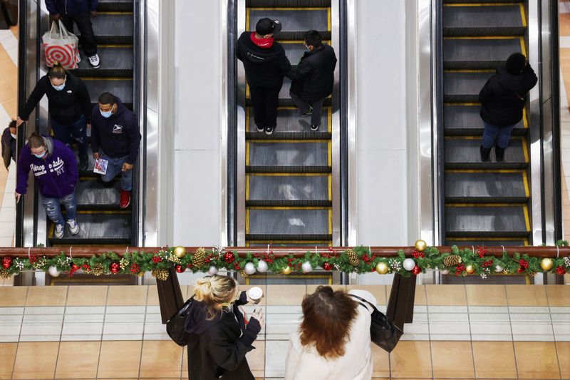 © Reuters. People ride an escalator while others stand at a mall during holiday season shopping as the Omicron coronavirus variant continues to spread in Brooklyn, New York City, U.S., December 18, 2021. REUTERS/Andrew Kelly