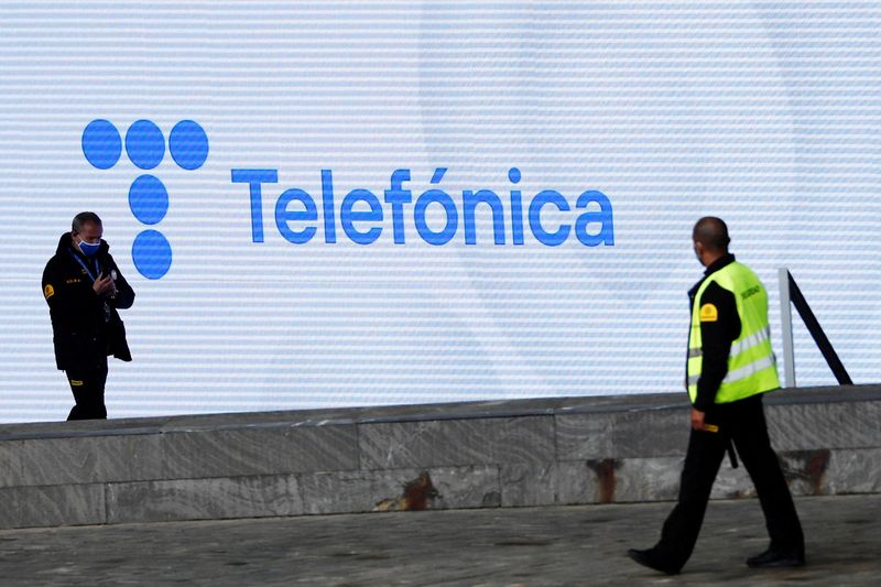 &copy; Reuters. FILE PHOTO: Security guards walk past a screen displaying the logo of Spanish Telecom company Telefonica at its headquarters in Madrid, Spain, May 12, 2021. REUTERS/Sergio Perez