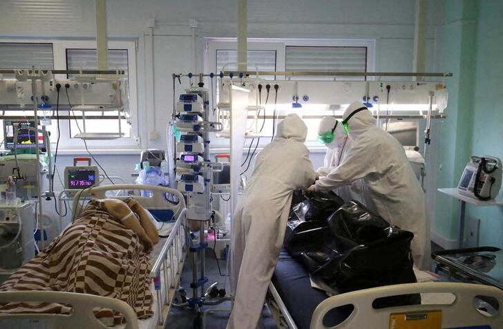 &copy; Reuters. Medical specialists place the body of a person who died at the ICU unit for coronavirus disease (COVID-19) patients in a bag at a local hospital in the town of Kalach-on-Don in Volgograd Region, Russia November 14, 2021. REUTERS/Kirill Braga     TPX IMAGE