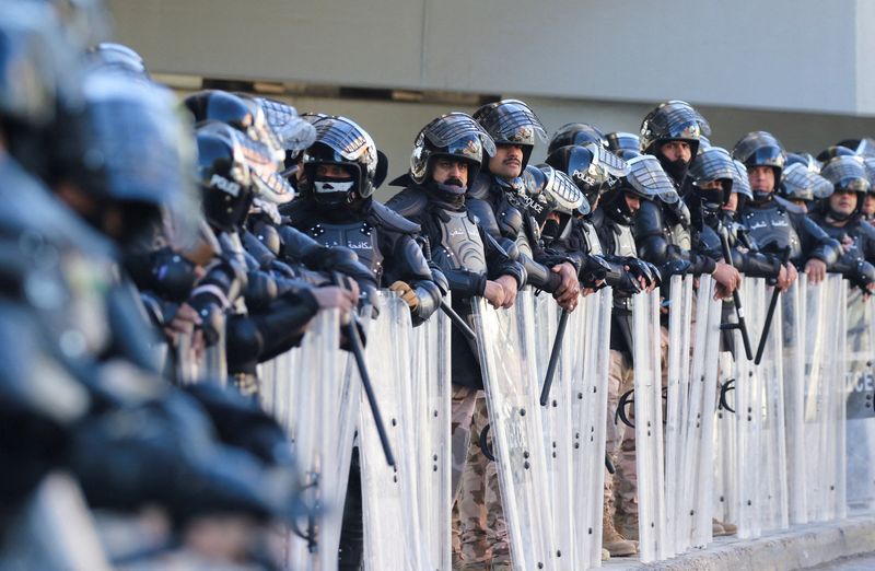 © Reuters. ضباط من قوات مكافحة الشغب العراقية يقفون أمام أنصار أحزاب شيعية أمام مقر المحكمة العليا العراقية يوم الاثنين. تصوير:احمد سعد-رويترز.