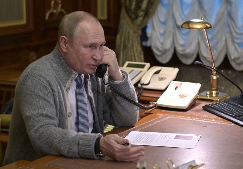 © Reuters. الرئيس الروسي فلاديمير بوتين يتحدث في الهاتف في مقر اقامته على مشارف سان بطرسبرج في روسيا يوم الاثنين. صورة لرويترز من وكالة سبوتنيك.