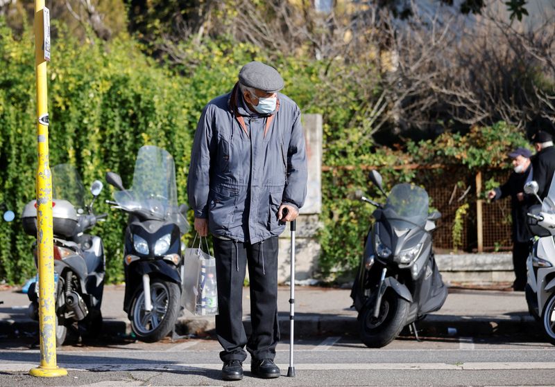 &copy; Reuters. FILE PHOTO: A man wearing a face mask waits for a tram, as the region of Lazio makes face masks mandatory outdoors in all areas, as coronavirus disease (COVID-19) cases rise and Christmas nears, in Rome, Italy, December 23, 2021. REUTERS/Yara Nardi