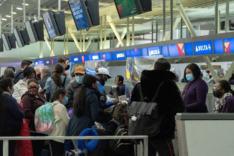 &copy; Reuters. FILE PHOTO: Travelers check in at John F. Kennedy International Airport during the spread of the Omicron coronavirus variant in Queens, New York City, U.S., December 26, 2021. REUTERS/Jeenah Moon/File Photo