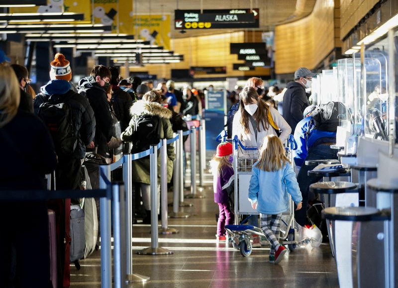 © Reuters. A family works through check-in at Alaska Airlines ticketing after dozens of flights were listed as cancelled or delayed at Seattle-Tacoma International Airport (Sea-Tac) in Seattle, Washington, U.S. December 27, 2021.  REUTERS/Lindsey Wasson