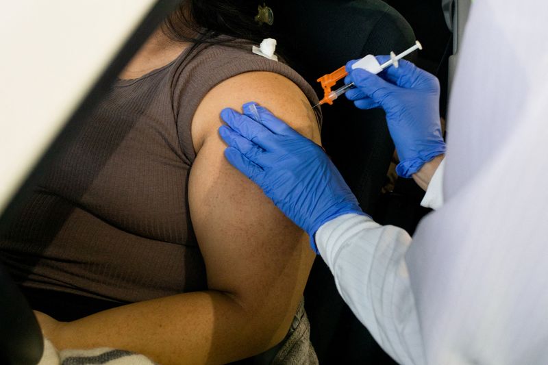 &copy; Reuters. A nurse administers a dose of the coronavirus disease (COVID-19) vaccine to a patient at Sparrow Laboratories Drive-Thru Services in Lansing, Michigan, U.S., December 27, 2021. REUTERS/Emily Elconin