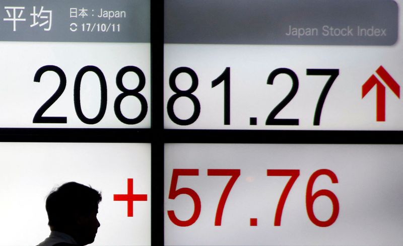 &copy; Reuters. A man walks past an electronic board showing Japan's Nikkei average outside a brokerage in Tokyo, Japan October 11, 2017. REUTERS/Toru Hanai