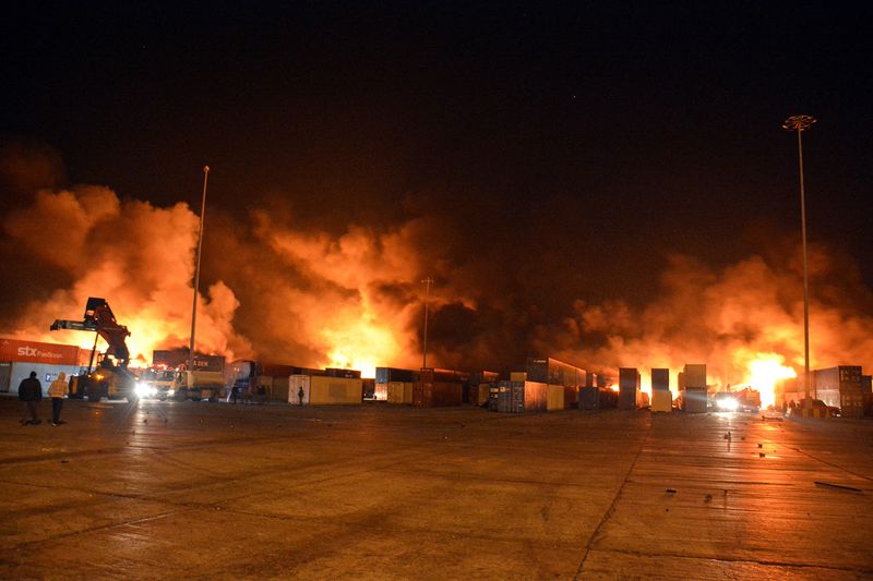&copy; Reuters. Una escuadra de bomberos intenta controlar un incendio en una parte del puerto sirio de Latakia, que según el Gobierno se debió a un ataque de Israel. Agencia de noticias SANA. Diciembre 28, 2021. SANA/Handout via REUTERS. ATENCIÓN EDITORES: ESTA IMAGE