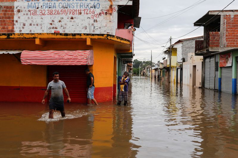 &copy; Reuters. Pessoas caminham por ruas alagadas em Itajuipe, na Bahia
27/12/2021
REUTERS/Amanda Perobelli